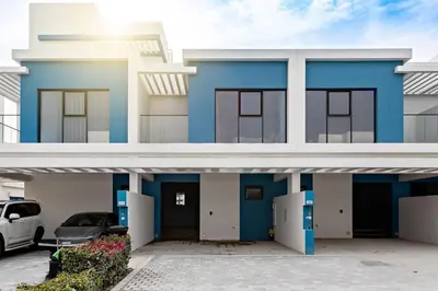a blue and white house with a car parked in front at Santorini Damac Lagoons Luxury 3BR Villa Mediterrean Bliss in Dubai