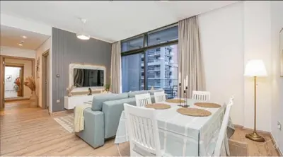 a living room with a blue couch and a table at Burj Khalifa and Canal view 2 BDR Apartment in Dubai