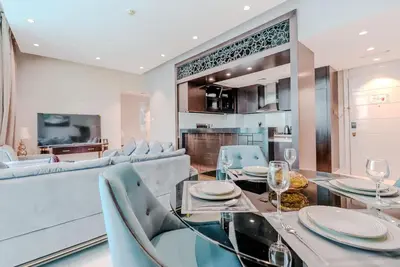 a dining room with a glass table and blue chairs at TRPS - Uppercrest, Downtown - Burj Khalifa View, Furnished, Near Dubai Mall in Dubai