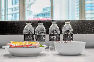 three bottles of water and a bowl of food on a table at TRPS - Uppercrest, Downtown - Burj Khalifa View, Furnished, Near Dubai Mall in Dubai