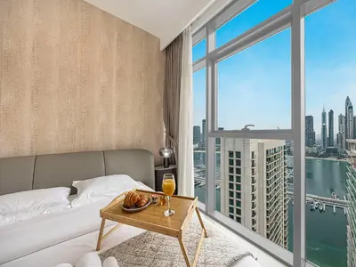 a bedroom with a bed and a view of a city at Livin' Holidays - 1 BR - Stunning Private beach in Dubai