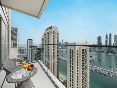 a balcony with a table and chairs and a view of a city at Livin' Holidays - 1 BR - Stunning Private beach in Dubai