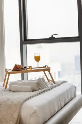 a table with a glass of wine on top of a bed at Livin' Holidays - 1 BR - Stunning Private beach in Dubai