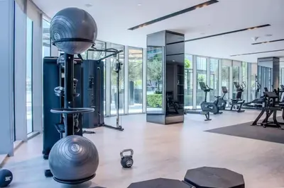 a gym with a lot of exercise equipment and windows at Versace 1BR Downtown Burj View From Infinity Pool in Dubai