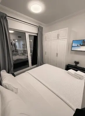a bedroom with a large white bed and a window at Luxury studio in Dubai Marina in Dubai