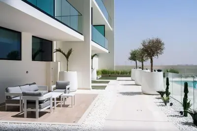 an exterior view of a building with tables and chairs at Luxe Studio Perch in Binghatti Azure with Pool & Gym in Dubai
