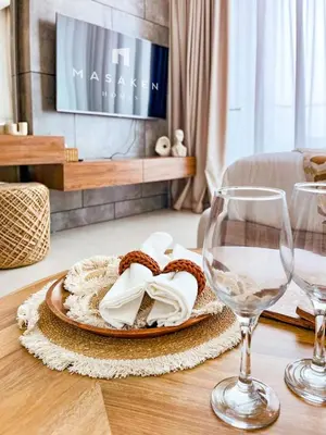 a table with two wine glasses and a plate of food at Luxe Studio Perch in Binghatti Azure with Pool & Gym in Dubai