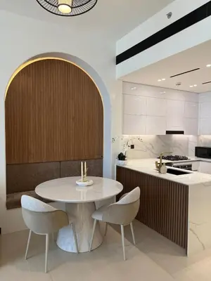 a kitchen with a white table and chairs at High floor luxury apartment JVC in Dubai