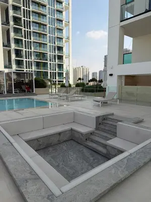 a building with a pool and stairs in a city at High floor luxury apartment JVC in Dubai