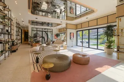 a lobby with tables and chairs in a building at Cozy 2BR Apartment in Dubai Hills with Cinema and Lounge Access in Dubai