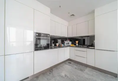 a white kitchen with white cabinets and appliances at Test Property - NoBookings in Dubai