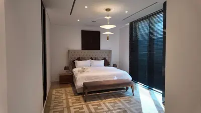 a bedroom with a white bed and a large window at Signature Palm Villa Exclusive 6 BDR Retreat in Dubai