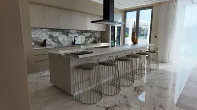 a kitchen with a island with bar stools at Signature Palm Villa Exclusive 6 BDR Retreat in Dubai