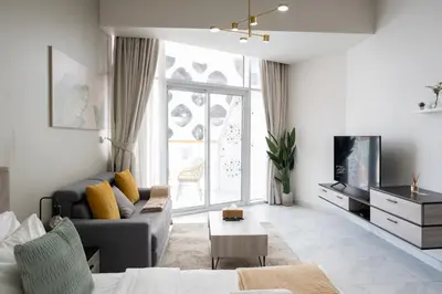 a living room with a couch and a tv at Stylish Apartment with Swimming Pool Near Dubai Mall and Burj Khalifa in Dubai