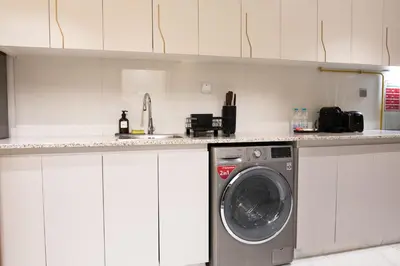 a washing machine in a kitchen with a counter at Stylish Apartment with Swimming Pool Near Dubai Mall and Burj Khalifa in Dubai