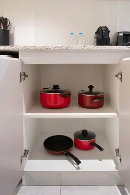 three pots and pans on a shelf in a kitchen at Stylish Apartment with Swimming Pool Near Dubai Mall and Burj Khalifa in Dubai