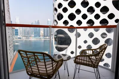 two chairs on a balcony with a view of the water at Stylish Apartment with Swimming Pool Near Dubai Mall and Burj Khalifa in Dubai