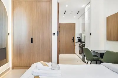 a bedroom with a bed and a kitchen with a table at Restay Homes at Binghatti Azure - Great City Escape - Swimming Pool Access in Dubai