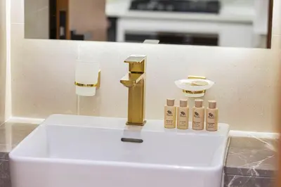a sink in a bathroom with a gold faucet at Restay Homes at Binghatti Azure - Great City Escape - Swimming Pool Access in Dubai