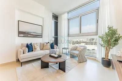 a living room with a couch and a table at Community View 1BR, Perfect Location Near Miracle Garden, Butterfly Garden and Community Spaces, Orion Building, Arjan by Deluxe Holiday Homes in Dubai