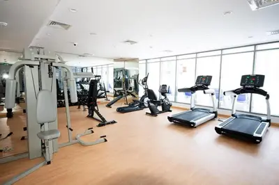 a gym with treadmills and elliptical machines at Modern Studio Apartment with Balcony in JVC in Dubai