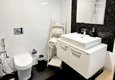 a white bathroom with a sink and a toilet at Modern Studio Apartment with Balcony in JVC in Dubai