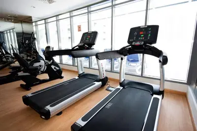 a gym with three exercise bikes in a room at Modern Studio Apartment with Balcony in JVC in Dubai