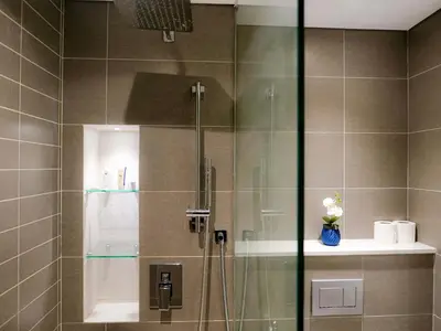 a shower with a glass door with a vase of flowers at Full Dubai Marina View 2BR Apartment in Dubai