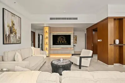 a living room with white furniture and a tv at Stunning 2BR with Burj Lake View at The Residences in Dubai