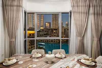 a dining room table with a view of a city at Stunning 2BR with Burj Lake View at The Residences in Dubai