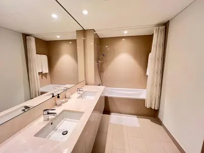 a bathroom with two sinks and a bath tub at 2BR next to Dubai mall with Khalifa Tower view! in Dubai