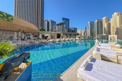 a large swimming pool with lounge chairs and buildings at Waves - Modern Comfort 1BR Apt at JW Marriott Marina Mall in Dubai