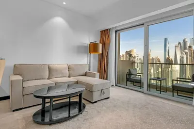 a living room with a couch and a large window at Waves - Modern Comfort 1BR Apt at JW Marriott Marina Mall in Dubai