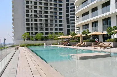 a swimming pool with chairs and umbrellas next to a building at Luxury 2BR Private Beach Partial Sea View in Dubai