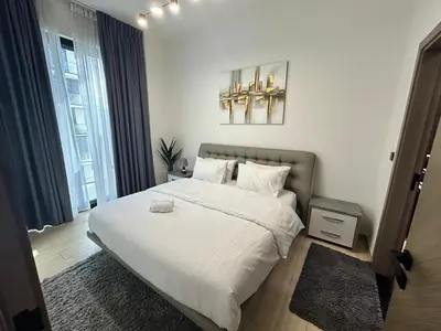 a bedroom with a large bed with white sheets at Chic 1bhk Smart Apartment, near circle Mall in Dubai