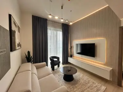 a living room with a couch and a tv at Chic 1bhk Smart Apartment, near circle Mall in Dubai