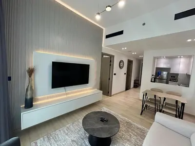 a living room with a flat screen tv on a wall at Chic 1bhk Smart Apartment, near circle Mall in Dubai