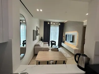 a living room with a table and a couch at Chic 1bhk Smart Apartment, near circle Mall in Dubai