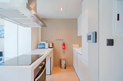 a kitchen with white cabinets and a counter top at Modern Studio with Skyline Views in Dubai Marina in Dubai