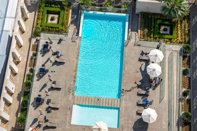 an overhead view of a pool with chairs and umbrellas at Modern Studio with Skyline Views in Dubai Marina in Dubai