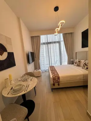 a bedroom with a bed and a table and a dining room at Beautiful Studio Brand New in Dubai
