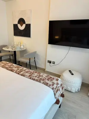 a hotel room with a bed and a table and a tv at Beautiful Studio Brand New in Dubai