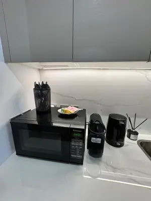 a microwave on a kitchen counter with a plate on it at Beautiful Studio Brand New in Dubai