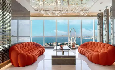 a room with two orange chairs and a large window at Sky Palace 3 Bedroom Penthouse on JBR in Dubai