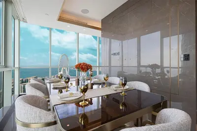 a dining room with chairs and a table with wine glasses at Sky Palace 3 Bedroom Penthouse on JBR in Dubai