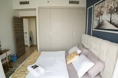 a living room with a white couch with pillows at Bloom Tower B-Stunning View-Luxurious Furnish-Pool View in Dubai