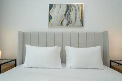 a bed with two pillows and a painting above it at Luxury 1 Bed Address JBR Direct Beachfront Living in Dubai