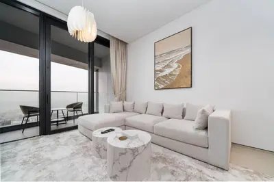 a white living room with a couch and a table at Luxury 1 Bed Address JBR Direct Beachfront Living in Dubai
