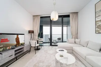 a living room with a white couch and a tv at Luxury 1 Bed Address JBR Direct Beachfront Living in Dubai