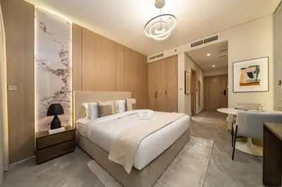 a bedroom with a large white bed and a bathroom at Stylish Modern Peninsula One Studio, Business Bay in Dubai